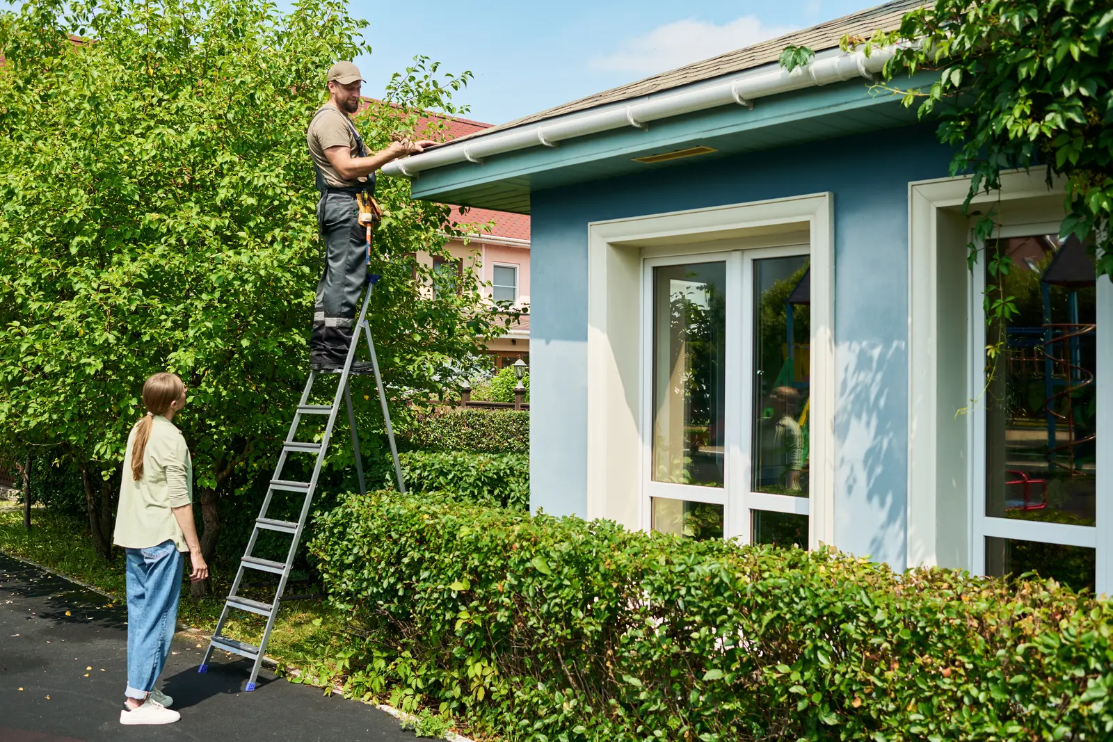 A roofing contractor speaking with a homeowner outside their house