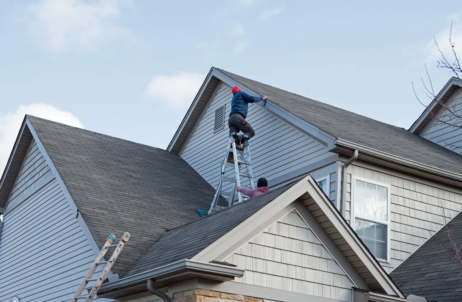 Roofer repairing a section of an asphalt shingle roof